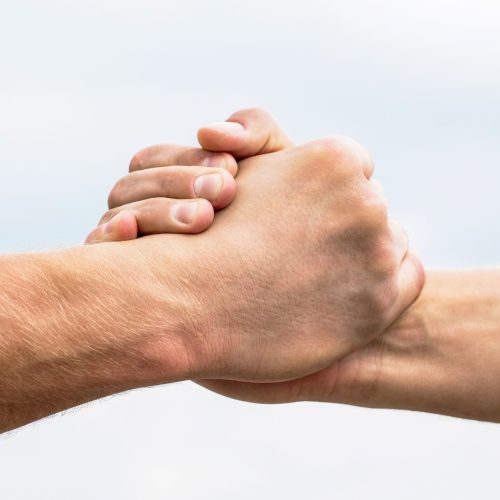 Rescue, helping gesture or hands. Two hands, helping arm of a friend, teamwork. Helping hand outstretched, isolated arm, salvation. Friendly handshake, friends greeting, teamwork, friendship.